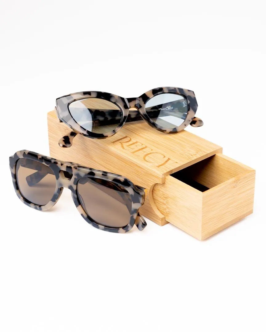 Reecy sunglasses styled on a wooden glasses box