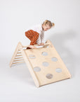 toddler climbing foldable montessori triangle in cozy nursery with soft natural lighting