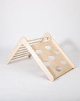 toddler climbing foldable montessori triangle in a sunlit playroom, showcasing adjustable slopes for active play