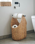 Luxury handwoven water hyacinth toilet paper holder, stylish modern bathroom storage with wooden handle, natural woven basket design by Ella James at brixbailey.com