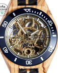 Premium handmade wooden watch for men, crafted from recycled olive and chacate preto wood with exposed gold mechanical movement by The Sustainable Watch Company at brixbailey.com