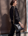 Black Leather Crossbody Handbag with Metallic Accents