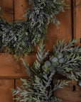 Frosted pine wreath with realistic frost effect, pinecones, and silver-green accents for winter home decor. by sostter at brixbailey.com