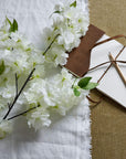White plastic cherry blossom stem with cascading petals, 100 cm tall, perfect for spring floral arrangements.by Sostter at brixbailey.com