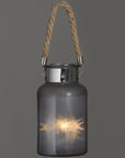 Frosted grey glass lantern with rope handle and warm LED glow, creating a starlight effect for indoor or outdoor decor. by RoomLondon at brixbailey.com