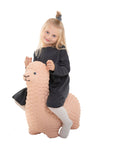 confident toddler on a beige alpaca jumpy hopper, ready for active indoor play