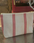 Linen union toiletry bag with red stripes, compact travel organizer, stylish vintage design, durable zipper closure, best-selling gift for men and women by Maison Elhoria at brixbailey.com