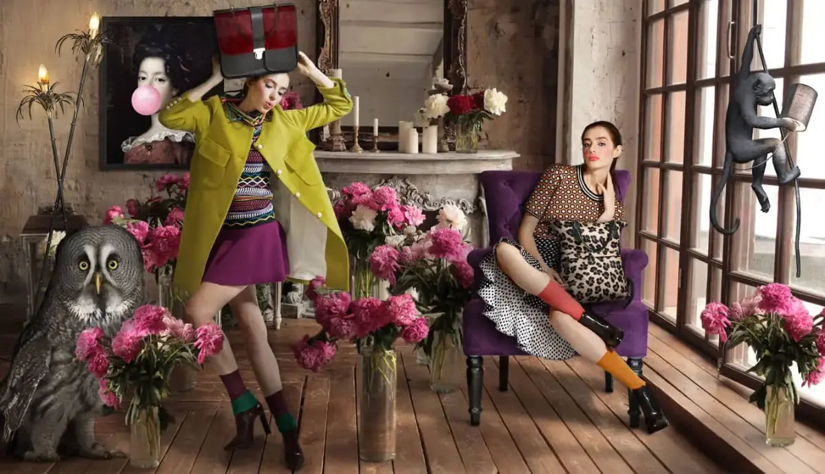 Two women in bold eclectic fashion pose among pink flowers, Brix + Bailey vintage furniture, owl and monkey lamp in a curated interior