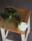 Lifelike white artificial rose stem with realistic petals and green stem, perfect for home decor or floral arrangements. by sostter at brixbailey.com