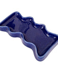 speckled blue ceramic wave tray on a wooden table, holding keys and coins, practical and stylish