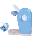 playful toddler pretending to be a barista with a wooden coffee machine and pods