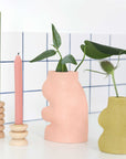elegant pink fluxo ceramic vase on a mantel in soft morning light