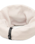 a soft white sand dog neck warmer in cozy indoor light