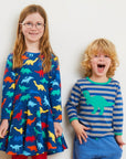 Premium organic cotton long sleeve kids shirt with embroidered T-Rex applique, stylish dinosaur collection, soft GOTS certified fabric by Toby Tiger at brixbailey.com