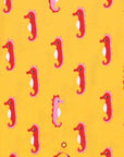 Luxury baby romper with short legs, playful seahorse design, red trim, snap buttons, organic cotton, sustainable fashion by Toby Tiger at brixbailey.com