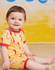 Luxury baby romper with short legs, stylish seahorse design, red trim, snap buttons, organic cotton, sustainable fashion by Toby Tiger at brixbailey.com