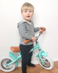 confident toddler on a marshall balance bike with 10-inch air tires on a sunny path
