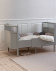 Premium Sebra baby and junior cot bed in stylish stone grey, luxury Nordic beech wood design with adjustable mattress and height-adjustable base by Ella James at brixbailey.com