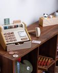 Premium wooden cash register toy, educational play set with coins, scanner, credit cards, and fabric receipt roll by Ella James at brixbailey.com