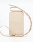 soft beige leather phone bag with a comforting glow, held gently in hand
