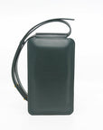 a soft forest green leather crossbody phone bag held gently in natural light, showing its smooth texture and elegant sam browne button