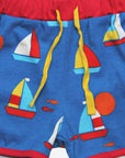 Premium organic sailboat print shorts, stylish red trim, adjustable yellow drawstring, soft GOTS-certified cotton, eco-friendly dyes by Toby Tiger at brixbailey.com
