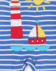 Dream of the next seaside vacation with this charming organic cotton baby sleepwear featuring sailboat and lighthouse applique, blue-white stripes, and red trim for a nautical vibe, slip-on neckline and snap buttons for comfort by Toby Tiger at brixbailey.com