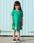 Premium green summer dress with short sleeves, GOTS certified organic cotton, stylish fruit appliques, red trim, Toby Tiger kids fashion by Toby Tiger at brixbailey.com