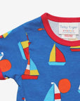 Premium organic cotton kids summer T-shirt with sailboat print, stylish red trim, deep blue background, playful fish details, GOTS certified, easy snap neck by Toby Tiger at brixbailey.com