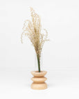 bold statement totem vase in beech wood with glass tube on a dark background