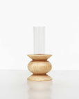 playful short totem wooden vase with a single bright flower in a sunlit room
