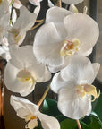 Faux orchid centerpiece in white vase