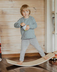 a bold, low-angle shot of a modern wooden balance board on a minimalist background