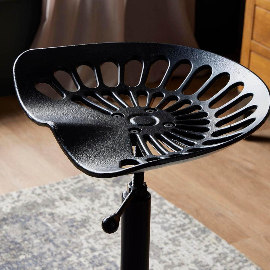 Black metal adjustable tractor stool with ergonomic seat for industrial-chic decor by Sostter at brixbailey.com