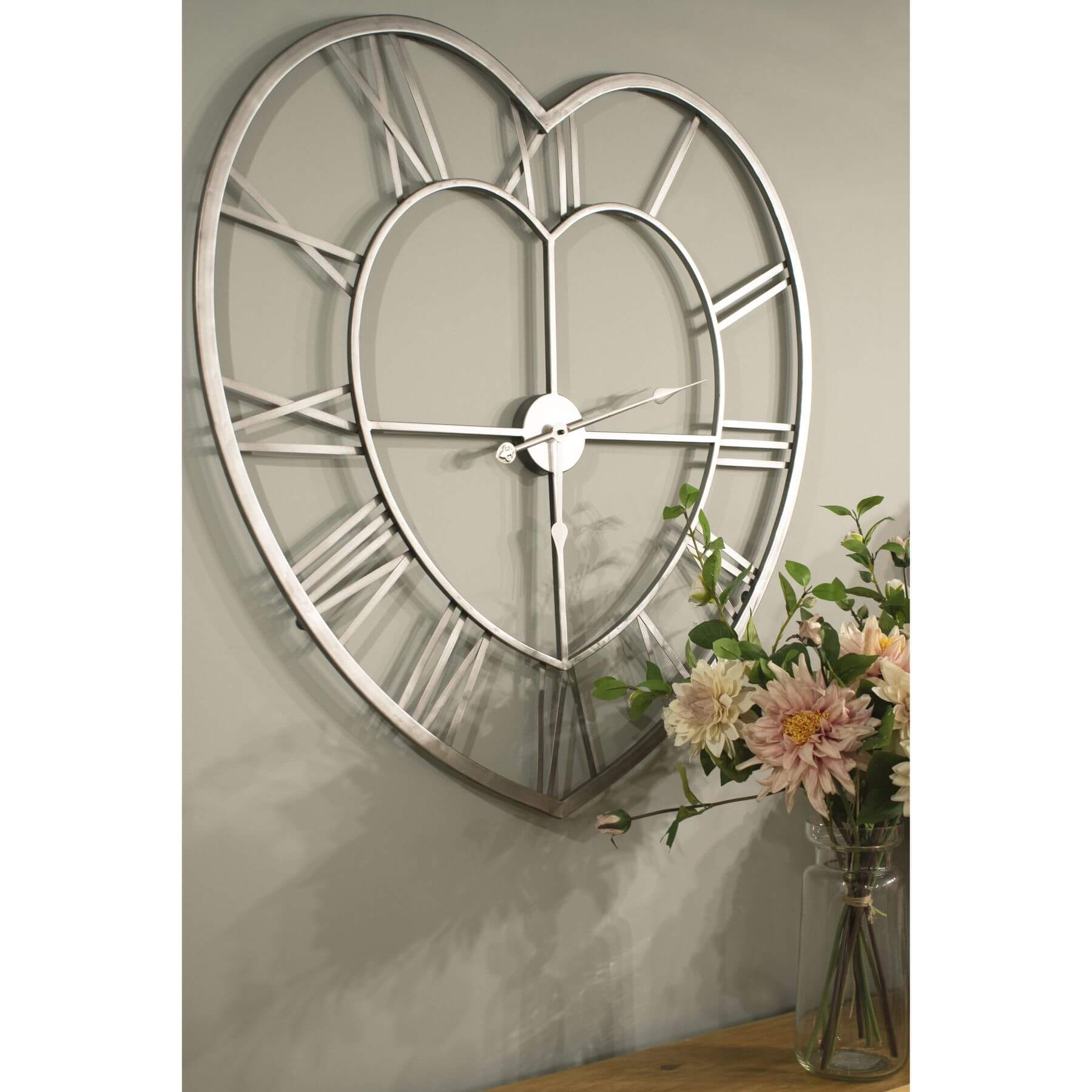 Heart-shaped skeleton wall clock in polished silver with roman numerals, minimalist metal design, 89cm diameter by sostter at brixbailey.com