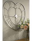 Heart-shaped skeleton wall clock in polished silver with roman numerals, minimalist metal design, 89cm diameter by sostter at brixbailey.com