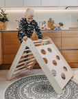soft-lit montessori climbing triangle folded in cozy nursery, inviting toddlers to explore safely