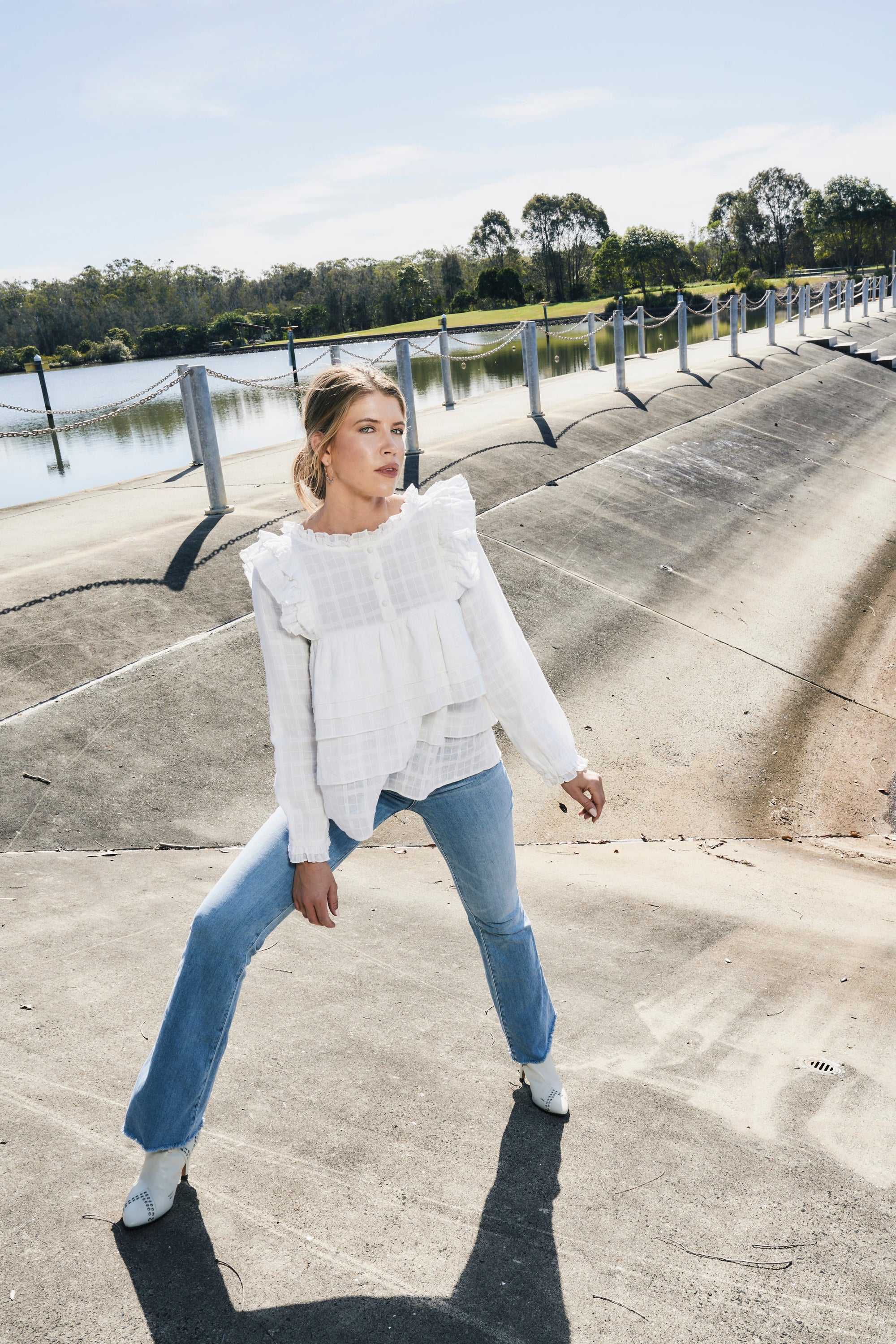 Luxury cream tiered blouse with ruffled shoulders, feminine frilled details, and soft textured cotton fabric by GILD at brixbailey.com