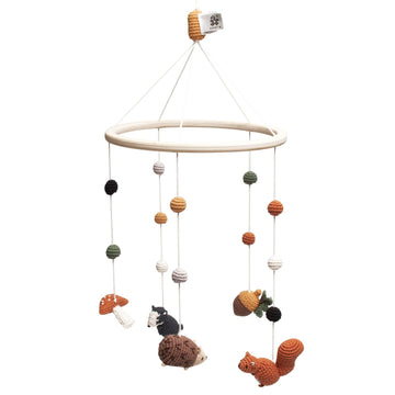 Premium crochet baby mobile with wooden ring, squirrel, badger, hedgehog, acorn, toadstool, and colorful balls, stylish nursery decor by Ella James at brixbailey.com