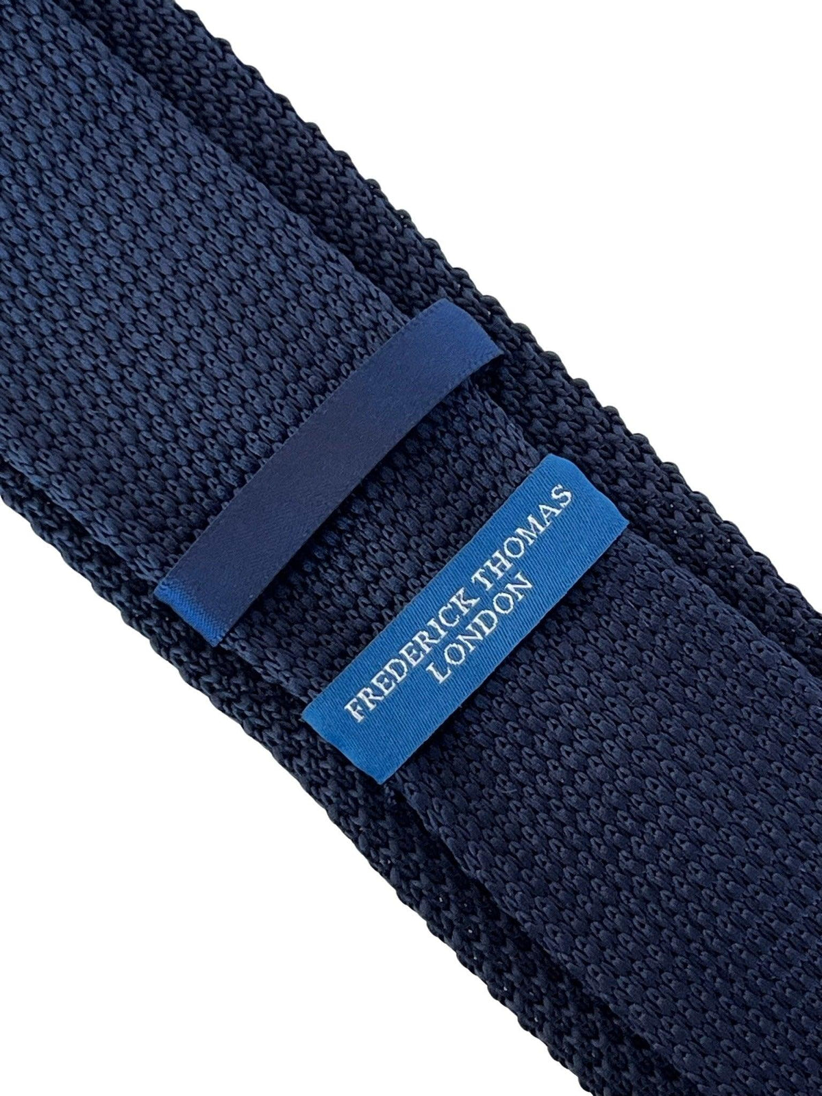 navy blue knitted tie with white embroidered fleur de lis lys design