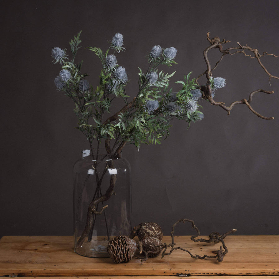 Artificial blue thistle stem with powder-blue petals and lifelike cone, perfect for rustic or coastal floral arrangements by Sostter at brixbailey.com