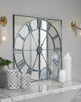 Celina mirrored wall clock with silver metal frame, modern skeleton design, and reflective glass surface, 112cm diameter by Sostter at brixbailey.com