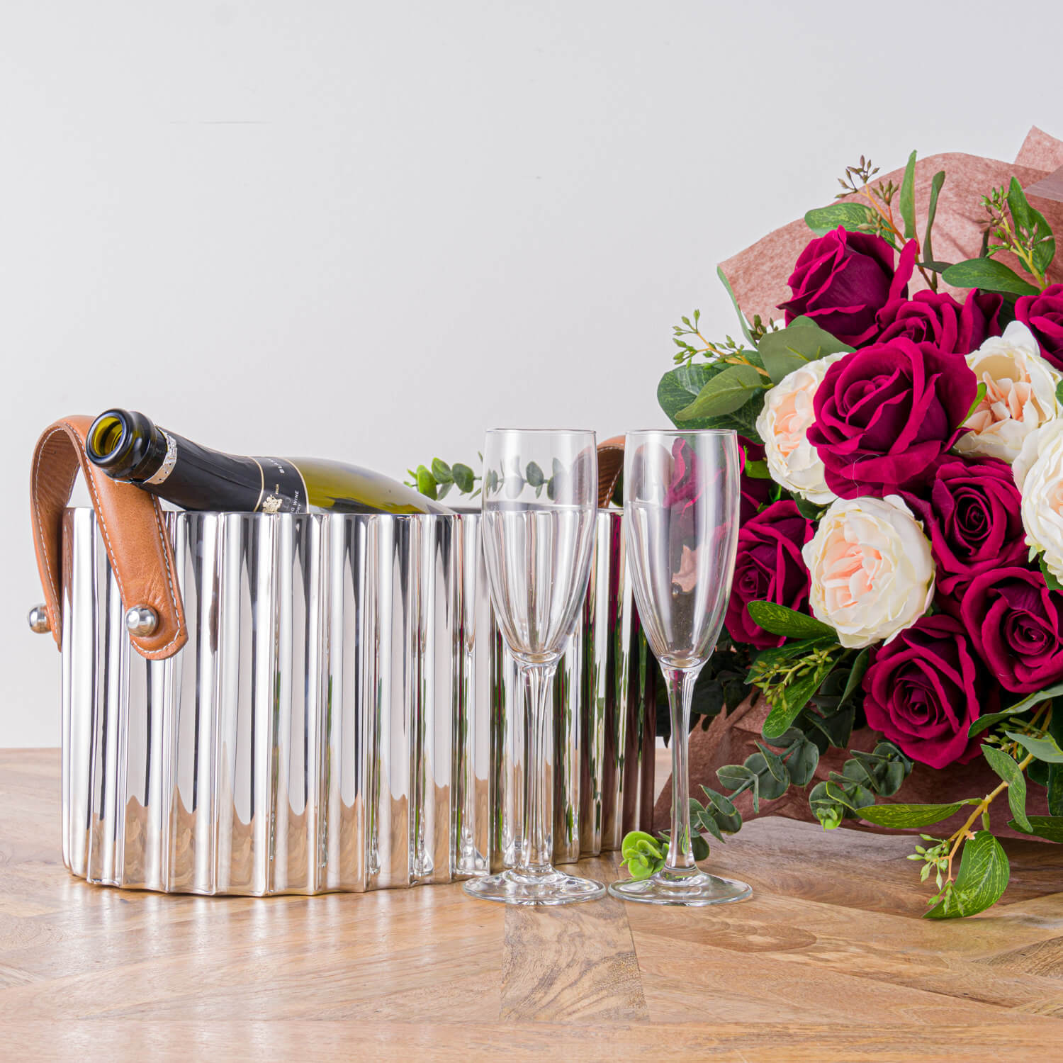 Silver champagne cooler with fluted metal body, leather handles, and mirror-polished finish for elegant entertaining by RoomLondon at brixbailey.com