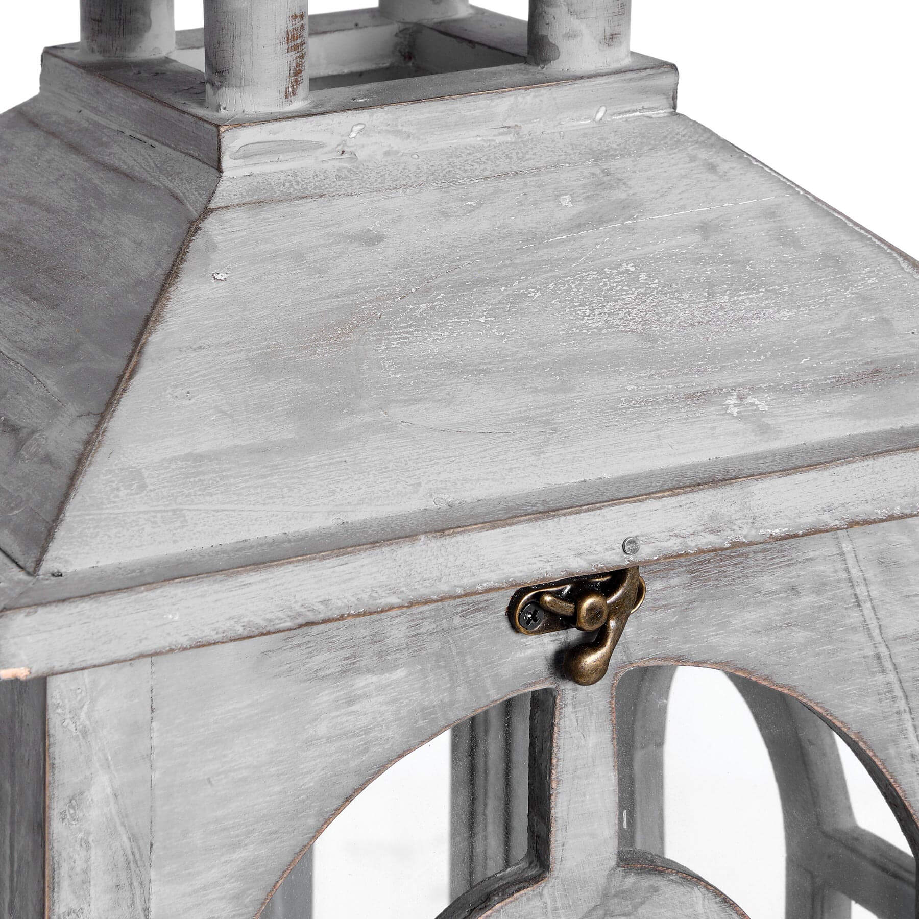 side view of a white-wash wooden lantern casting a soft, comforting glow through its archways