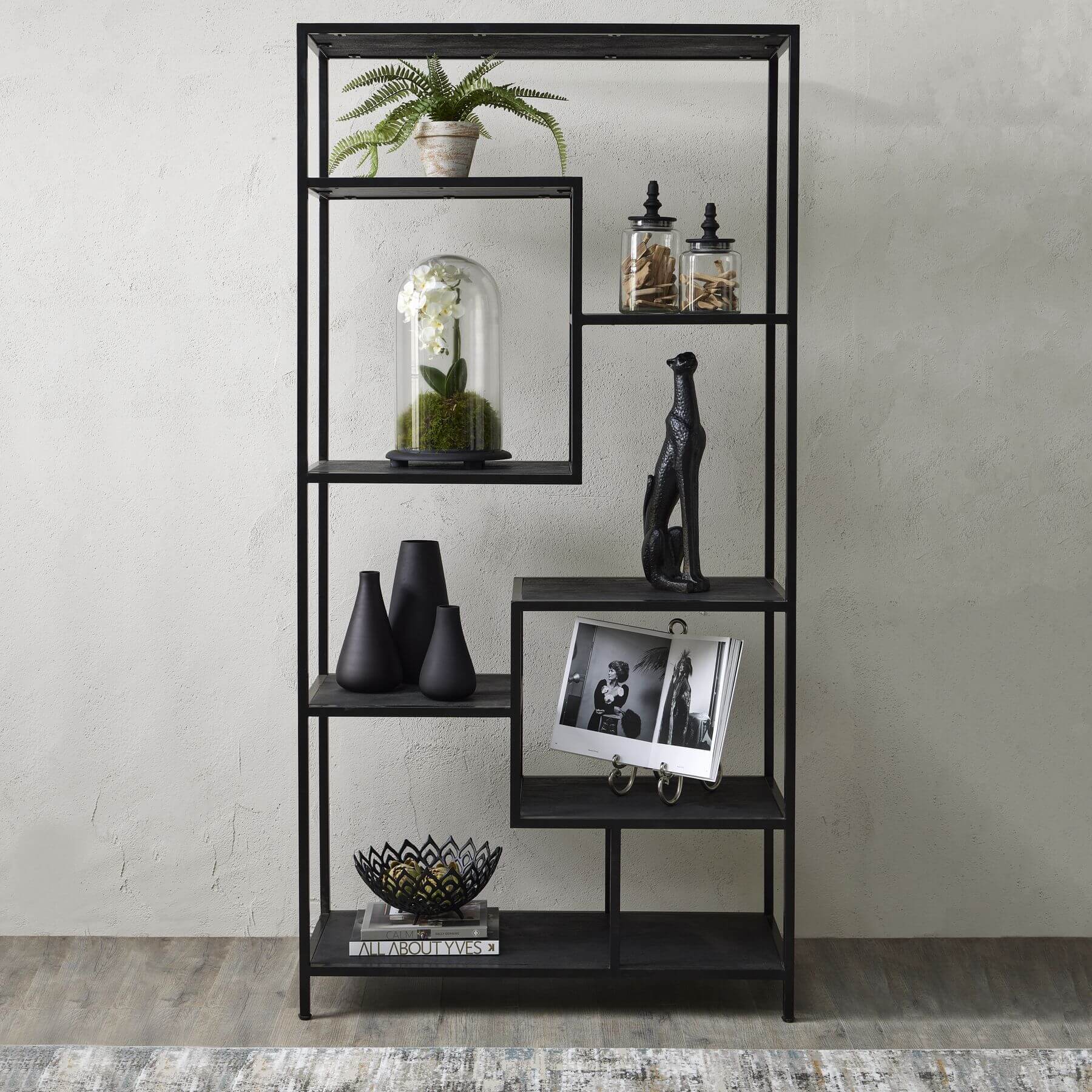 Black metal industrial shelf unit with asymmetrical seven-shelf design and lattice framework for modern home decor by Sostter at brixbailey.com