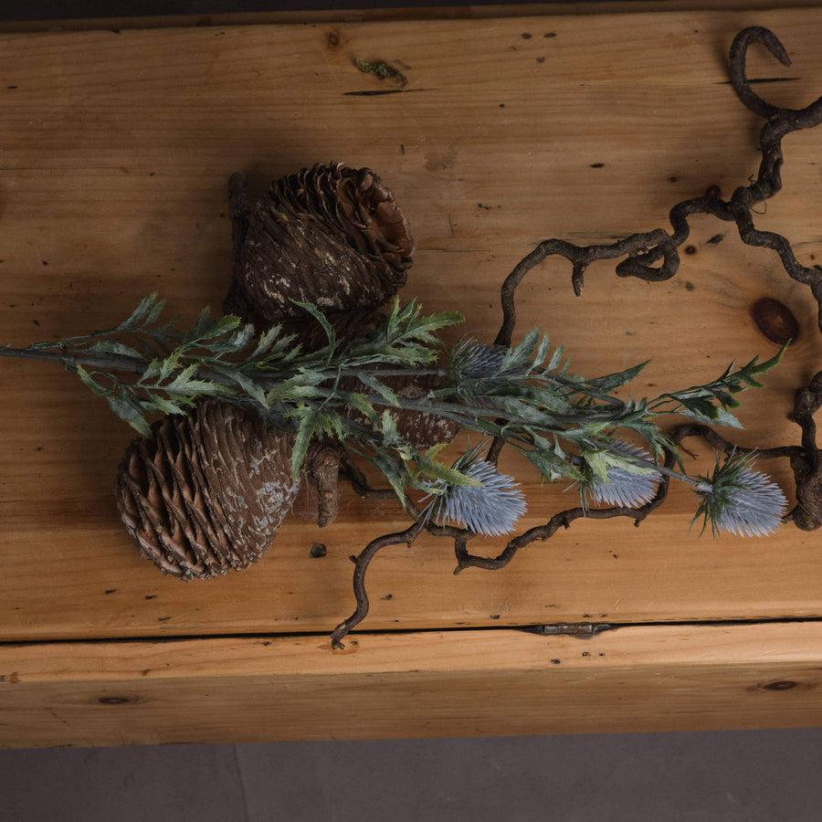 Artificial blue thistle stem with powder-blue petals, lifelike cone, 76cm tall, perfect for rustic or coastal decor. by Sostter at brixbailey.com