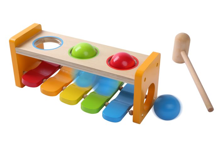confident shot of a toddler hammering balls on the vibrant wooden musical bench