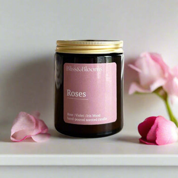 Luxury rose scented candle in amber glass jar with gold lid, handcrafted premium floral fragrance with bergamot, jasmine, wisteria by Bliss & Blooms at brixbailey.com