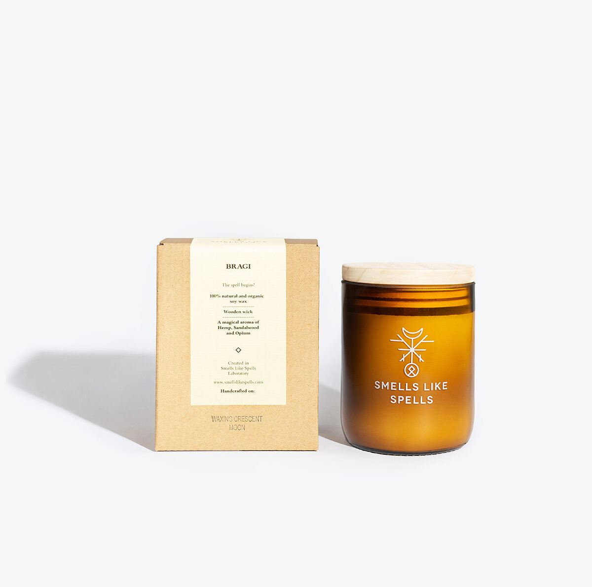 softly lit bragi candle in amber glass with a gentle wooden wick glow