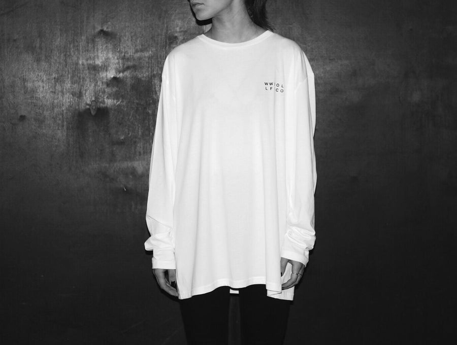 Luxury oversized white long sleeve tee with handprinted WWOOLLFF CO. graphics, premium organic cotton, stylish unisex design by WWOOLLFF CO. at brixbailey.com
